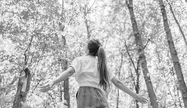 A woman in a forest taking in it.