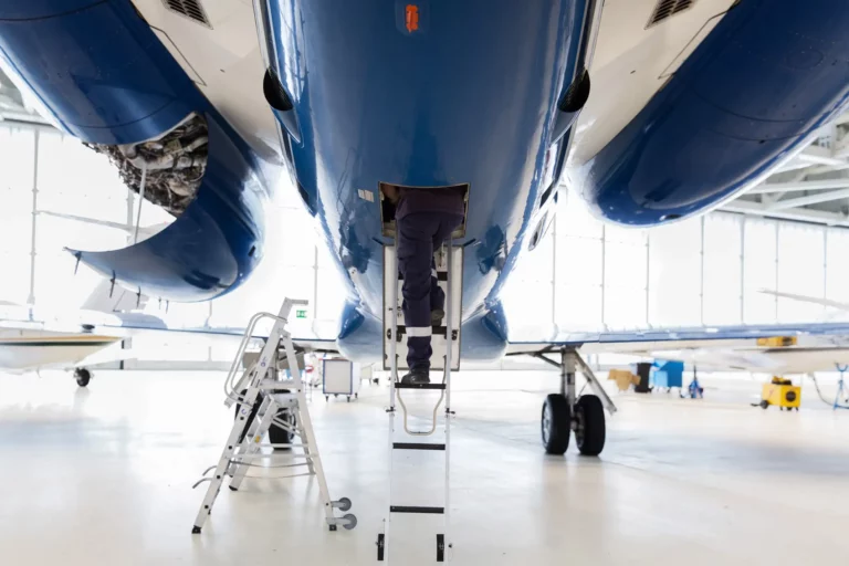 Technician working in the tail section of an business jet.