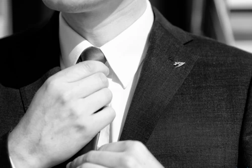 A pilot fixing his tie before welcoming a customer.