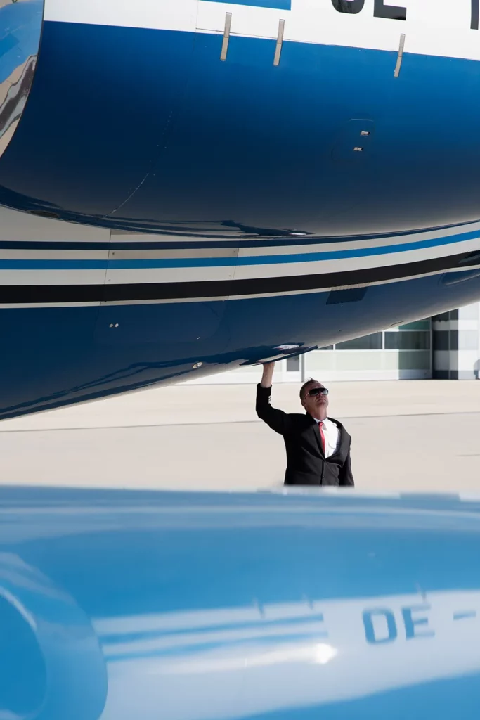 A pilot inspecting a jet before a aviation consulting meeting.