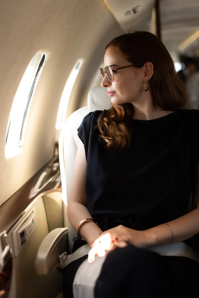 Passenger enjoying the view from a private jet window seat, illustrating the comfort of traveling on an Empty Leg flight.